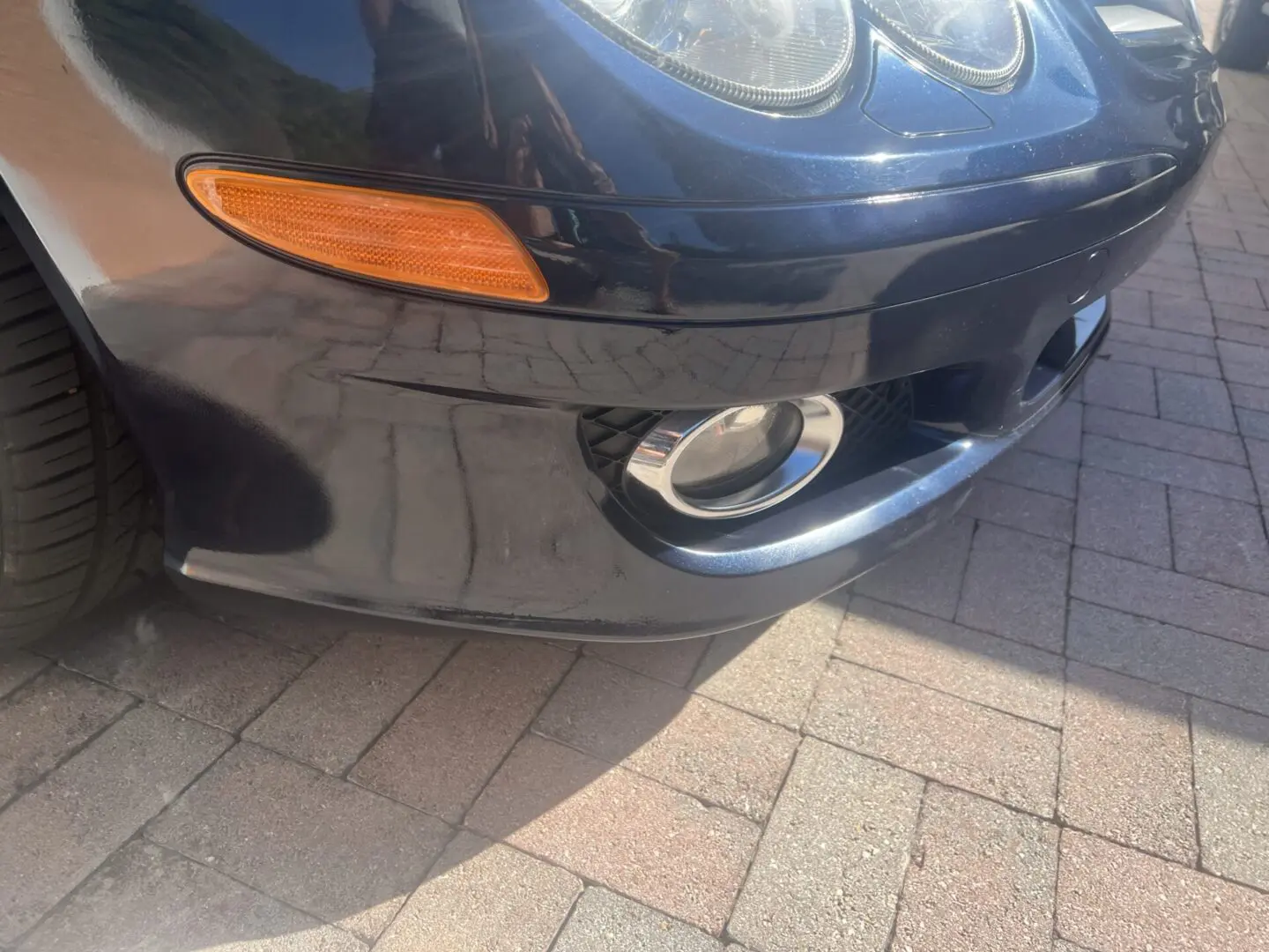 Close-up of car front bumper and headlight.