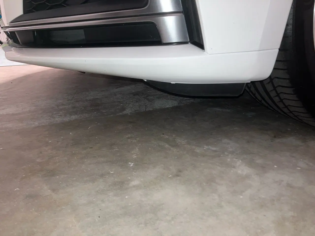 Car bumper and tire on concrete floor.