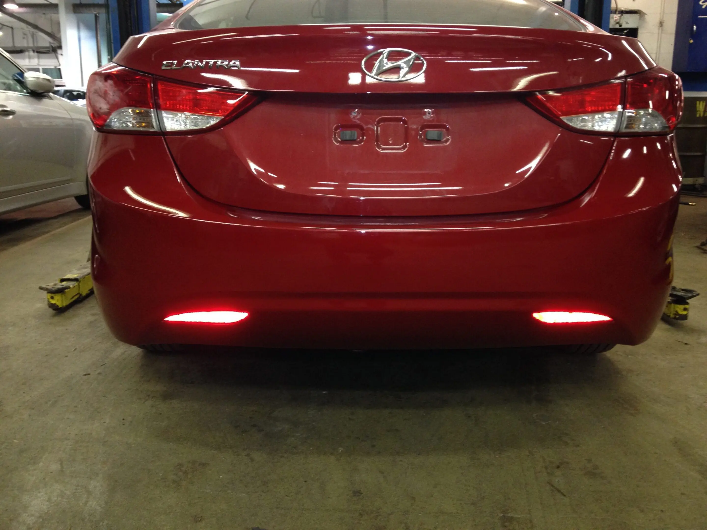 Rear view of a red Hyundai Elantra in a garage.