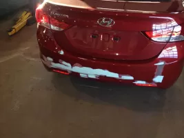 Red car with damaged rear bumper.