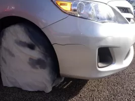Car with damaged front bumper and tire.