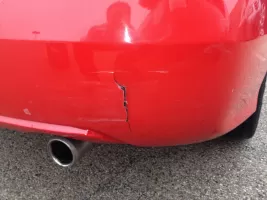 Red car bumper with visible crack damage.