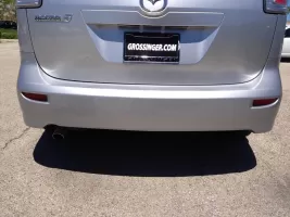 Silver Mazda car rear with dealership plate.