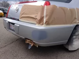 Car rear bumper with masking tape preparation.